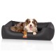 Ein glücklicher Australian Shepherd Hund liegt in einem stilvollen schwarzen Haustierbett mit lederähnlichem Finish, mit einem kleinen Logo-Tag.