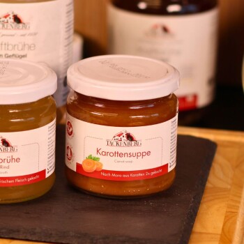Słoik z zupą marchewkową Tackenberg dla zwierząt, z etykietą pokazującą marchewki i tekstem po niemiecku i angielsku.