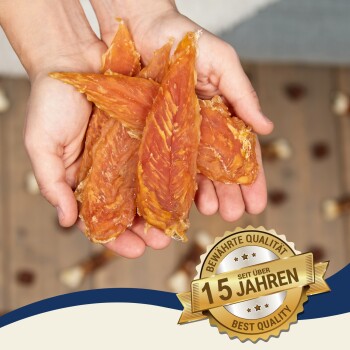 Hände halten mehrere Stücke getrockneter Hühnerleckerlis, mit einem Abzeichen, das "Beste Qualität" und "15 Jahre" auf Deutsch angibt.