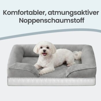 Kleiner weißer Hund auf grauem Bolster-Hundebett; Text lautet 'Komfortabler, atmungsaktiver Noppenschaumstoff'.