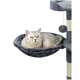 Eine hellgraue Katze mit grünen Augen, die in einer plüschigen, dunkelgrauen Hängematte liegt, die an einem Kratzbaum befestigt ist.