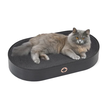 Eine flauschige graue Katze mit orangefarbenen Augen, die auf einem schwarzen ovalen Katzenbett mit strukturierter Oberfläche entspannt.