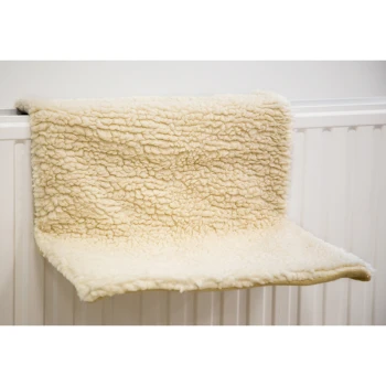 Ein weiches, cremefarbenes Haustierregal mit einer flauschigen Textur, das für Katzen oder kleine Haustiere zum Ausruhen konzipiert ist, an einer weißen Wand montiert.