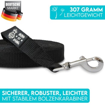 Schwarze Hundeleine mit einem stabilen Metallclip, mit einem Etikett, das 'HUND IST KÖNIG' liest. Der Text hebt ihr leichtes Gewicht (307 Gramm) und ihre Haltbarkeit hervor.