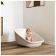 Flauschige Maine-Coon-Katze sitzt in einer beigen Plastik-Tierbadewanne auf Holzboden in einem modernen Raum.
