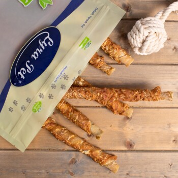 Eine Tüte mit Haustierleckereien, beschriftet mit 'Fruity Snack' und einem blauen Logo, die mehrere gedrehte Fleischstangen auf einer Holzoberfläche enthält.