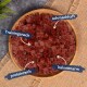 Eine Holzschüssel mit gewürfelten roten Hundeleckerlis, beschriftet auf Deutsch: "Trainingssnack", "schmackhaft", "proteinreich" und "kalorienarm".