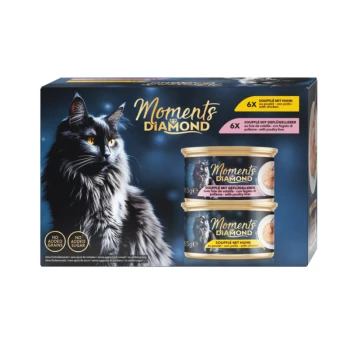 Un élégant chat noir aux yeux orange regarde le spectateur à côté d'une boîte de nourriture pour chat "Moments Diamond" avec des boîtes de poulet et de foie de volaille.