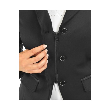 Nahaufnahme einer Hand einer Frau, die eine schwarze Jacke mit Reißverschluss und zwei dekorativen Knöpfen anpasst, die über einem weißen Oberteil getragen wird.