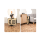 Eine Person trägt eine zusammenklappbare Haustiertrage in Beige und Schwarz, mit einer gemütlichen Wohnzimmerumgebung mit einem grauen Sofa und Holzmöbeln.