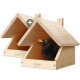 Zwei helle Holzvogelhäuser mit 'wildlife home'-Logo; eine Amsel lugt aus dem vorderen Haus und ein grünes Plus-Abzeichen ist sichtbar