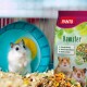 Ein neugieriger Hamster schaut aus einem blauen Rad neben einer Tüte Panto Hamsterfutter mit bunten Zutaten und ernährungsphysiologischen Höhepunkten.
