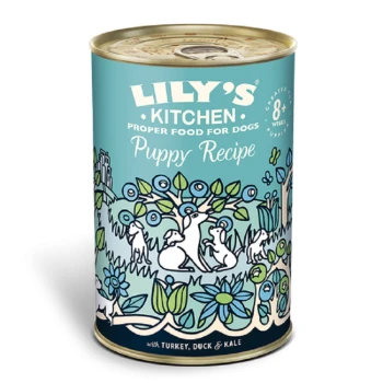 Can of Lily's Kitchen Puppy Recipe dog food, featuring a colorful illustration of dogs and plants, labeled with "with Turkey, Duck & Kale."