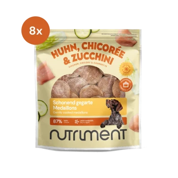 Packung mit Haustierfutter, das Huhn, Chicorée und Zucchini enthält, mit dem Etikett "Nutriment", mit einem Hundebild und "8x" in der Ecke.
