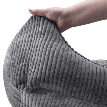 Eine Hand hält ein weiches, graues Haustierbett mit gerippter Textur, das sein plüschiges Material und komfortables Design zeigt.