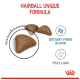 Cat food kibble labeled "Hairball Unique Formula," with three brown triangular pieces and icons for "Dietary Fibre Blend" and "Psyllium."