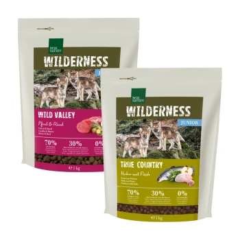 WILDERNESS Trockenfutter Hund, Junior, Probierpaket 2x 1kg Zwei Haustierfutterbeutel mit der Aufschrift 'Wilderness', die die Geschmäcker 'Wild Valley' und 'True Country' zeigen, jeweils mit Bildern von Wölfen und Nährwertinformationen.