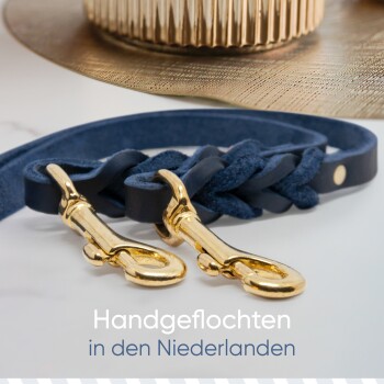 Handgefertigte marineblaue Haustierleine mit goldenen Verschlüssen, auf einer strukturierten Oberfläche präsentiert, mit dem Text "Handgeflochten in den Niederlanden."
