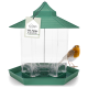 Ein grüner Vogelhaus mit hexagonalem Boden und einem spitzen Dach, beschriftet mit "XXL Futter Kapazität," neben einem kleinen Vogel mit orangefarbener Brust.