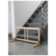 Holztiergitter mit Metallstäben, positioniert am Fuß einer Treppe, entworfen, um Haustiere sicher und eingesperrt zu halten.