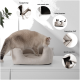 Eine helle Katze erkundet ein beiges Haustierbett auf einer weißen Oberfläche, mit Symbolen für handgefertigt, rutschfest, hohe Akzeptanz, angenehmer Stoff und waschbar.