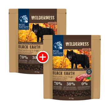 Zwei 1 kg Beutel Real Nature Wilderness Hundefutter, "Schwarze Erde," mit einem schwarzen Hund auf der Vorderseite, 70% Fleisch und 30% andere Zutaten.
