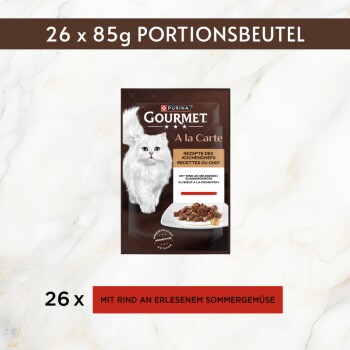 Purina Gourmet A la Carte Katzenfutterbeutel mit weißer Katze; zeigt '26 x 85g' und 'MIT RIND AN ERLESENEM SOMMERGEMÜSE.'