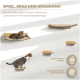 Eine getigerte Katze entspannt sich auf einem Holzregal, mit weiteren Regalen sichtbar. Text: "Spiel, Spaß und Spannung" und "Entworfen in Europa."