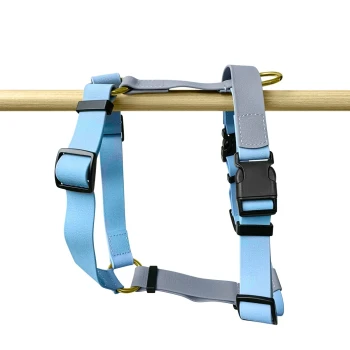 Führgeschirr – Outdoor FLEX – 5-fach verstellbar taupe S Hellblaues und graues verstellbares Haustiergeschirr, das an einer Holzstange hängt, mit schwarzen Schnallen und einem goldenen Ring.