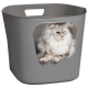 Ein grauer Aufbewahrungskorb mit einem Ausschnitt, in dem eine flauschige, grau-weiße Katze herausblickt und ihre auffälligen gelben Augen zeigt.