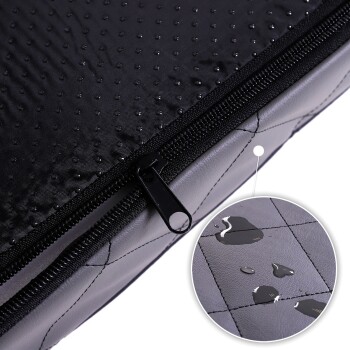 Nahaufnahme eines schwarzen Haustierbettes mit wasserdichtem Reißverschluss, mit einer strukturierten Oberfläche und Wassertropfen auf dem Stoff.