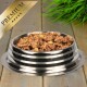 Gestreifte Edelstahlschüssel, gefüllt mit Nassfutter für Hunde, auf Holzboden, mit grüner Pflanze und goldenem Banner ‚PREMIUM‘.