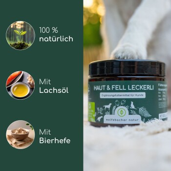 Ein Glas mit Hundesupplementen, beschriftet mit "HAUT & FELL LECKERLI", mit natürlichen Zutaten wie Lachsöl und Bierhefe, mit einer Pfote im Hintergrund.