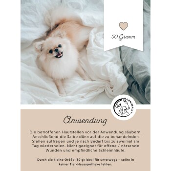 Ein flauschiger Pomeranian-Hund, der auf weißer Bettwäsche liegt und in die Kamera lächelt. Das Bild enthält einen Text über die Anwendung einer 50-Gramm-Salbe für Haustiere.