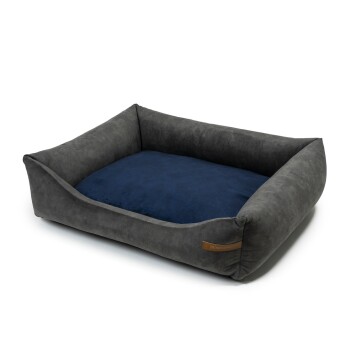 Graues Hundebett mit einem marineblauen Kissen, mit erhöhten Seiten für Komfort und einem kleinen Lederetikett an der Seite.