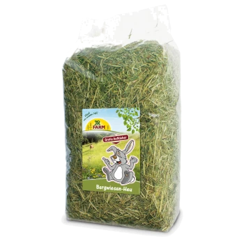 Un sac en plastique transparent rempli de foin vert étiqueté "JR FARM Bergwiesen-Heu," présentant un lapin de dessin animé et le texte "Gratis Aufkleber."