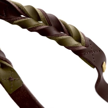 Eine Nahaufnahme eines geflochtenen Lederhalsbands für Hunde mit dunkelbraunen und olivgrünen Riemen, sichtbaren Nähten und einem goldenen Akzent.