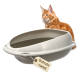 Orangefarbene Maine-Coon-Katze hinter einer beige ovalen Katzentoilette mit hohem Rand, hängendes Schild mit der Aufschrift 'Schutz -rand'.