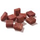 Ein Haufen kleiner, rötlich-brauner Haustierfutterwürfel auf einem weißen Hintergrund angeordnet.