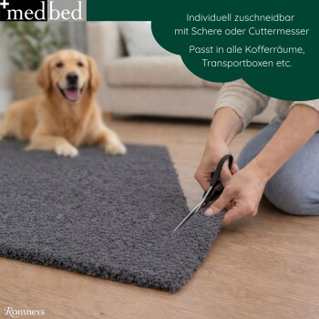 Hände schneiden eine graue Hundematte mit einer Schere; Golden Retriever im Hintergrund; sichtbares 'medbed'-Logo und Text 'Individuell zuschneidbar'.