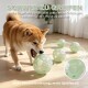 Shiba Inu beißt in eine hellgrüne, perforierte 15 cm (5,9 in) Kugel; sichtbarer deutscher Text 'SCHWER ZU GREIFEN' und 'Mehr Spielspaß'.
