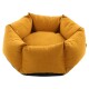 Rundes, plüschiges Haustierbett in einem warmen senfgelben Farbton mit einem weichen, gepolsterten Innenraum und schwarzem Boden.