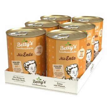 Sechs Dosen Betty's Landhausküche Hundefutter, beschriftet mit "Mit Ente," mit einem orangefarbenen Design und einer Kochillustration, in einem Papptray präsentiert.
