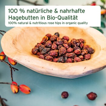 Schüssel mit getrockneten Hagebutten auf einer blauen Oberfläche mit dem Text: "100% natürliche & nahrhafte Hagebutten in Bio-Qualität."