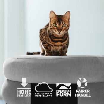 Eine Bengal-Katze sitzt auf einem plüschigen grauen Haustierbett, mit Symbolen darunter, die hohe Stabilität, umweltfreundliche Produktion, ergonomisches Design und fairen Handel anzeigen.