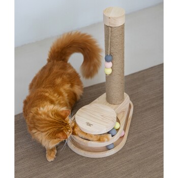 Eine verspielte orange Katze interagiert mit einem Holzspielzeug für Katzen, das einen Kratzbaum und bunte Bälle in einer runden Basis enthält.