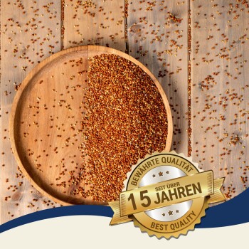 Eine Holzschüssel gefüllt mit bunten Samen, mit einigen verstreut auf einer Holzoberfläche. Ein Abzeichen liest "Beste Qualität" und "10 Jahre" auf Deutsch.