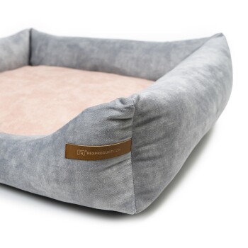 Graues Haustierbett mit einem weichen rosa Innenraum und einem braunen Etikett mit der Aufschrift 'RexProduct.com' an der Seite.