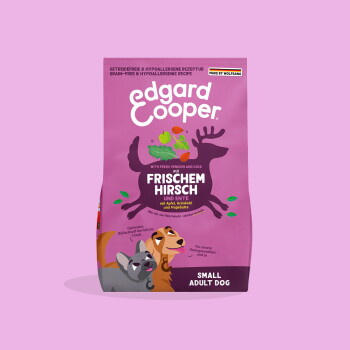 Rosa Edgard Cooper Hundefuttertüte mit Hirsch-Silhouette und zwei Cartoon-Hunden; Beschriftungen 'Frischem Hirsch' und 'Small Adult Dog'.