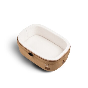 Ein gemütliches, ovales Haustierbett aus tanfarbener Stoff mit einem weichen weißen Innenraum, entworfen für kleine Haustiere.